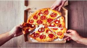 Pizza pepperoni dividia em oito fatias, mão de três pessoas pegando uma fatia cada